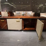 Refined TV Stand with Quilted Upholstered Panels, Natural Wood Veneer Finish and Brushed Stainless Steel Handles